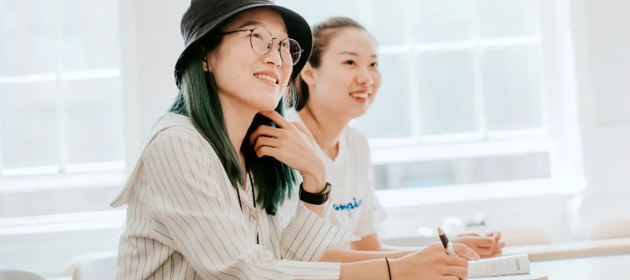 Two students sitting at a table, smiling